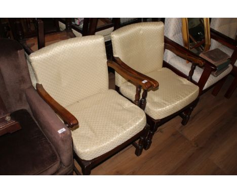 A pair of vintage oak armchairs, upholstered in a patterned cream material with block and turned supports, 76.5 cm with a sea