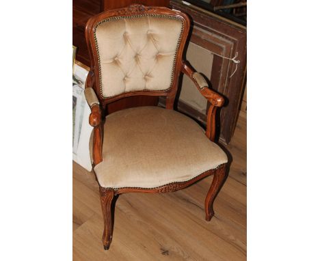 A modern reproduction mahogany framed armchair in 19th century style, the shaped back with foliate carving over a deep button