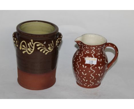 A Wetheriggs dark brown and white trailed glazed pottery two handled cylindrical kitchen jar, 20 cm high, a light brown and w