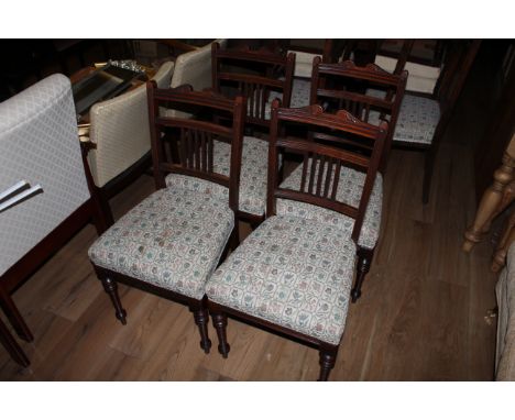 A set of 4 19th century mahogany dining chairs, having scrolled and incised top rails over a reeded mid rail and 5 vertical s