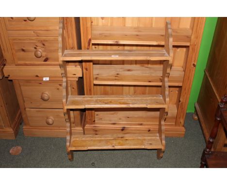 A small pine wall hanging plate rack with 3 shelves between shaped ends. 92 cm x 60 cm x 14 cm.  CONDITION REPORT: Each shelf