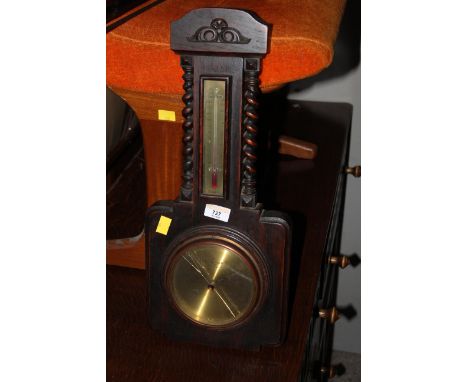 A 1930's oak barometer and thermometer with spiral turned supports and brass dials, 49 cm high. CONDITION REPORT: The glass t