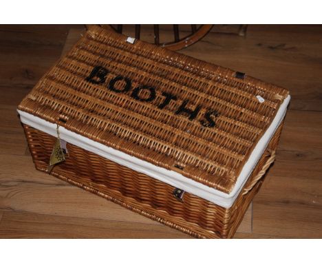 A Booths branded woven wicker hamper, 27 cm x 59 cm x 37 cm, sold together with a modern moulded framed mirror decorated with