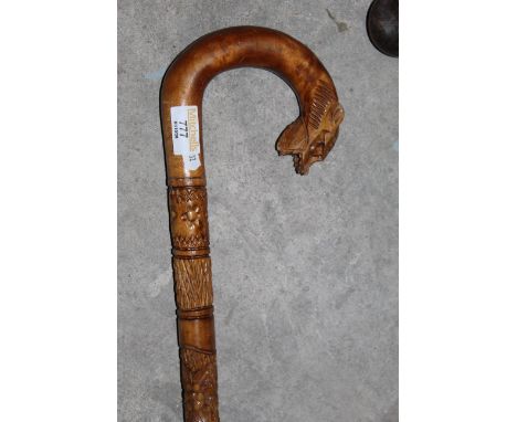 An African carved hardwood walking stick with lion head terminal. 88 cm long. CONDITION REPORT: This walking stick is in good