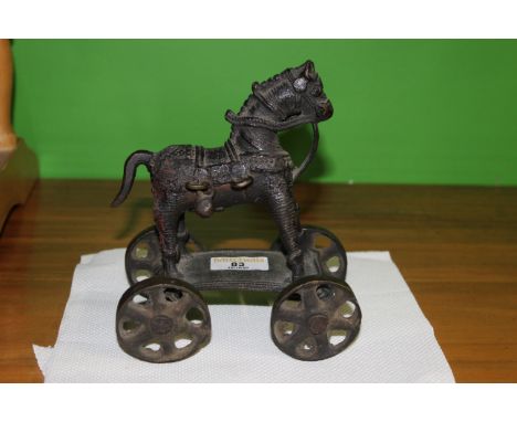 An unusual Indonesian ground painted bronze model of a hobby horse on wheels, 18 cm high. CONDITION REPORT: This model is in 