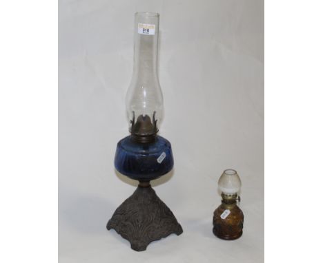 A Victorian cast and coloured glass oil lamp, the tapering base embossed or cast with Art Nouveau style decoration, the blue 