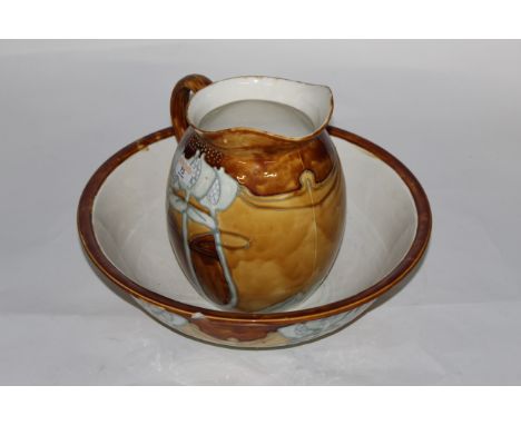 A Minton secessionist pottery wash jug and basin, decorated in tan, brown and blue with stylised flowers, the jug 26 cm high,