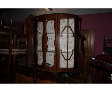 A 1940's figured walnut bow front display cabinet fitted two plate glass shelves on cabriole legs. 99 cm wide x 34 cm deep x 