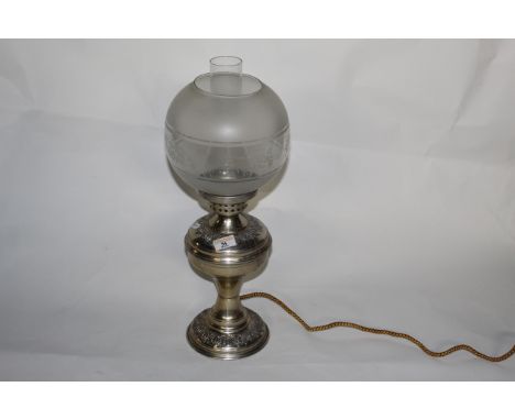 An embossed white metal table oil lamp with chimney and etched glass shade, 51 cm high (converted to electricity).   CONDITIO
