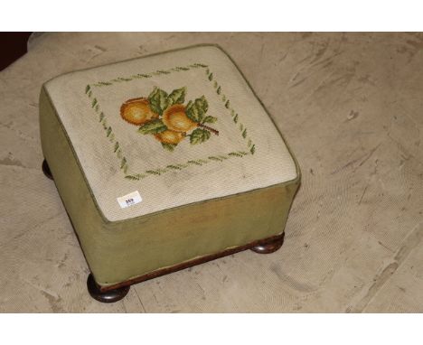 A Victorian needlework footstool of square form, the needlework top depicting oranges within a foliate border, raised on a sl