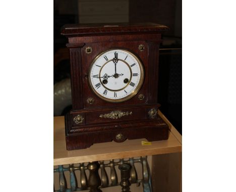 An early 20th century brass mounted oak mantle clock, having a rectangular top with geometric moulded edge over an enamelled 