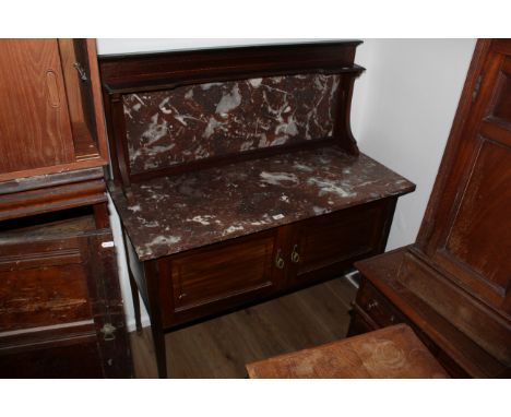 An Edwardian inlaid mahogany marble topped washstand, the raised variegated marble back with slender inverted breakfront shel