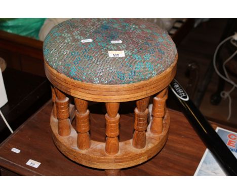 A modern light oak circular footstool, the padded top over and incised seat rail and supported by multiple turned spindles, t