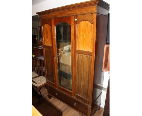 An Edwardian inlaid mahogany mirror door wardrobe, having a moulded cornice and stringing laid frieze over the central arched