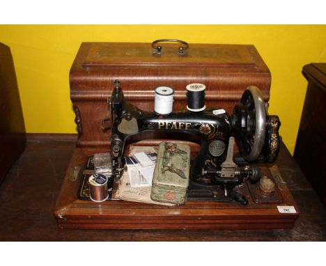 A late 19th century Pfaff manual sewing machine with inlaid rosewood veneered case, 50 cm x 25cm x 30 cm high, together with 