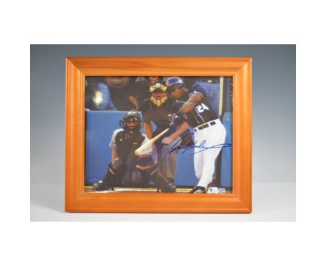 Framed action photograph featuring Rickey Henderson, the legendary Hall of Fame outfielder, captured mid-swing during a game.
