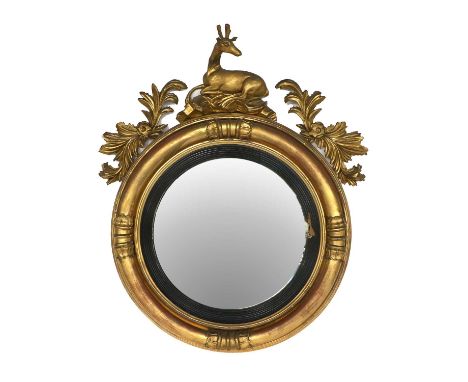 A William IV Giltwood and Ebonised Convex Mirror, 2nd quarter 19th century, the reeded and ebonised slip in a moulded leaf-de