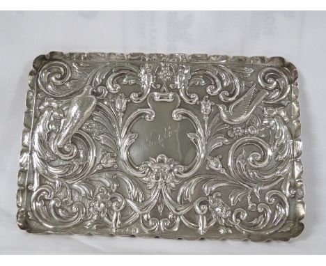 Oblong silver tray with repousse scrolled foliage, mask heads and birds, the central reserve engraved 'Gelythe', piecrust rim