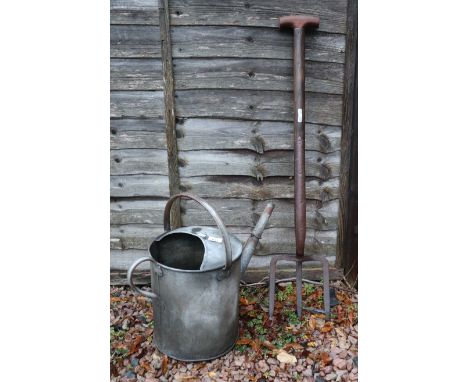 Galvanised watering can together with vintage potato fork