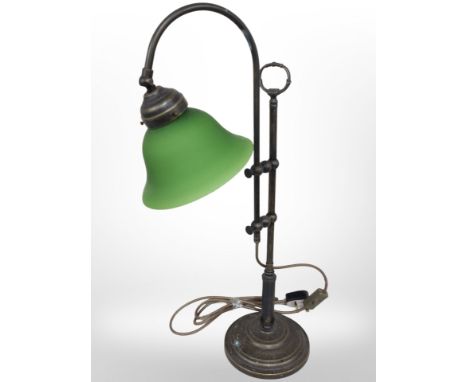 A reproduction brass rise and fall desk lamp with green glass shade.