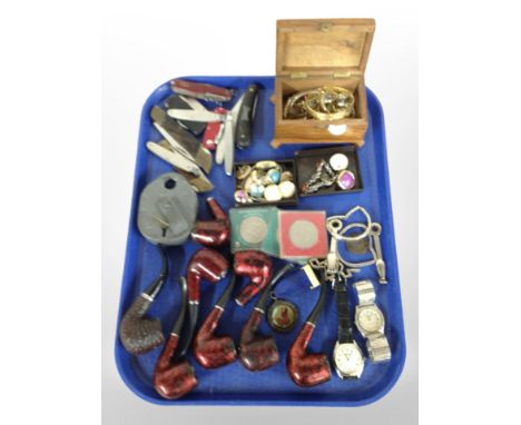 A group of pipes, folding knives, Swiss Army Knife, costume jewellery, wristwatches, vintage padlock, crowns.
