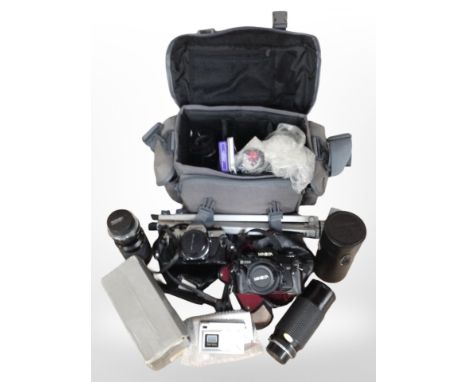 A collection of cameras and lenses including Olympus, Minolta, Tamron, a modern camera bag containing related photography acc