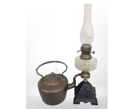 A Victorian copper kettle and an oil lamp with cast-iron base and clear glass reservoir, height 62cm.