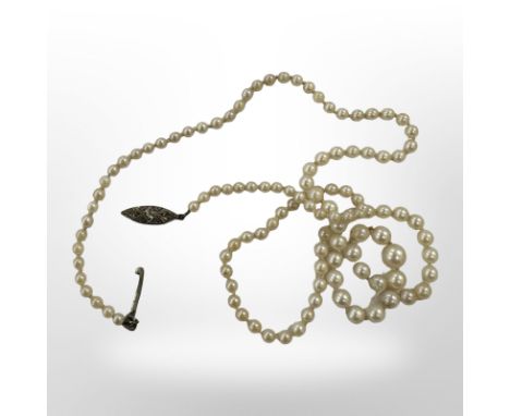 A single-stand pearl necklace with white gold diamond-set clasp, requires re-stringing 
