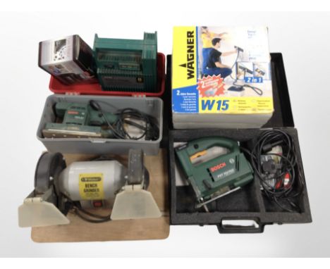 A group of power tools including Bosch jigsaw and sander, battery charger, tyre inflater, a bench grinder, etc.