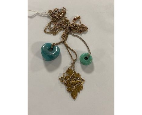A polished blue quartz heart pendant on chain, a turquoise doughnut-shaped pendant on silver chain, a gold-plated moth pendan