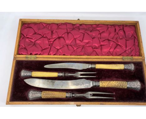 An inlaid oak cased carving set by Harrison Bros. &amp; Howson, with horned handles and hallmarked silver mounts. 