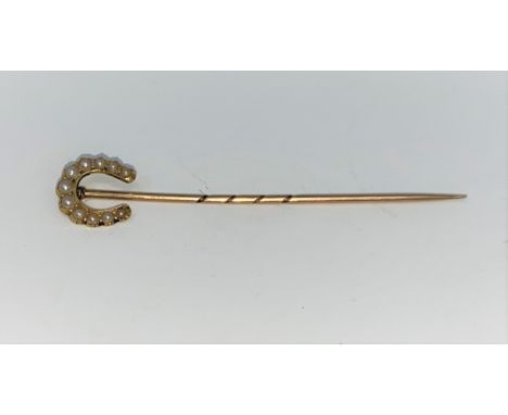 A yellow metal seed pearl set, horseshoe pin. Stamped 15ct  (1.5g) 