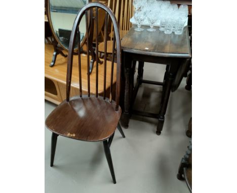 A 1930's oak drop leaf dining table with oval top; 4 Ercol hoop and stick back chairs 