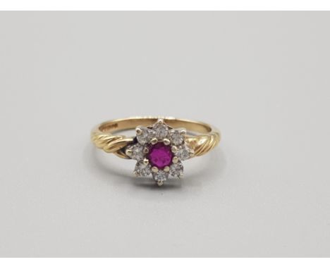 Ladies 9ct yellow gold ruby and diamond cluster ring comprising of a ruby set in the centre surrounded by 8 brilliant round c