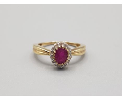 Ladies 9ct yellow gold ruby and diamond cluster ring comprising of a oval ruby in the centre surrounded by 14 brilliant round