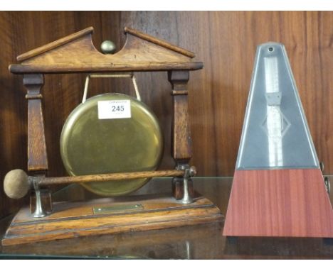 A MAHOGANY AND BRASS TABLE GONG TOGETHER WITH A METRONOME