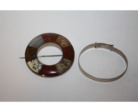 A SCOTTISH STYLE POLISH AGATE CIRCULAR BROOCH TOGETHER WITH A STERLING SILVER CHRISTENING BANGLE