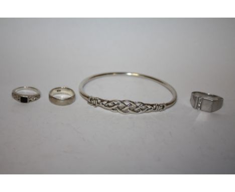 A STERLING SILVER BANGLE AND THREE SILVER DRESS RINGS