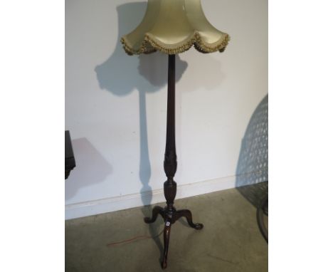 A 1920’s mahogany standard lamp with shade, with Corinthian carved column terminating in a tripod cabriole leg base with claw