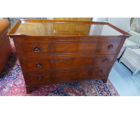 A modern three drawer chest, glass topped over three long drawers raised on bracket supports - 140cm x 56cm x 95cm high 