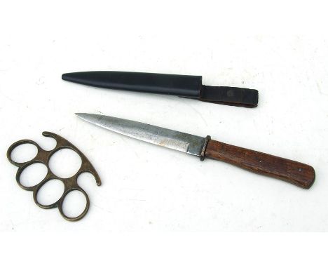 A WW1 trench knife with a 14.5cms (5.75ins) blade in its steel scabbard together with a set of brass knuckles or knuckleduste