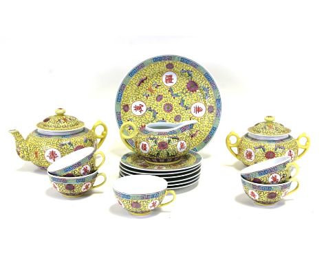 A 20th century Chinese part tea set decorated with foliate scrolls and characters on a yellow ground.Condition ReportOne cup 