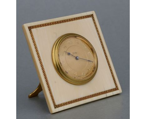 An early 20th century ivory framed strut clock, the dial with Arabic numerals within a yellow metal Greek key border and havi