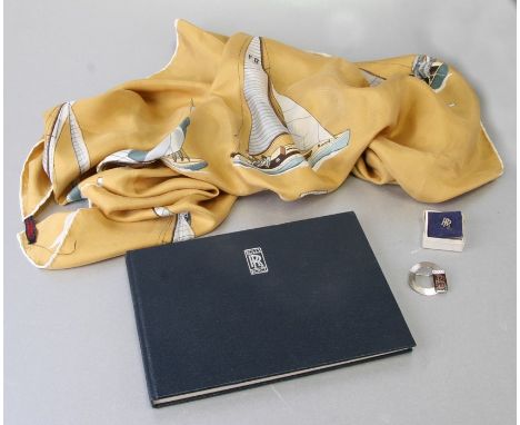 Rolls Royce interest.  An enamel lapel brooch; together with another similar; a silk scarf and a History of Rolls Royce (4).