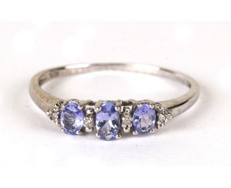 A 9ct white gold ring set with three tanzanite's interspersed with diamonds, weight 1.4g, approx UK size 'R'.Condition Report