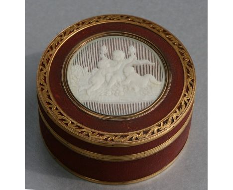 An 18th century red lacquer snuff box of circular form, the top with circular pierced ivory panel depicting three cherubs wit
