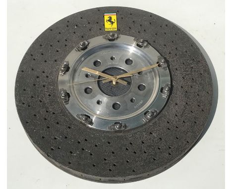 A Ferrari themed wall clock constructed from a 360 Stradale Challenge Carbonfibre Brembo disc, fitted with a quartz movement,