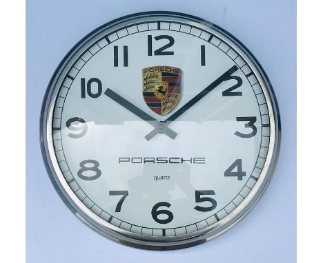 A Porsche themed wall clock, the white dial with Arabic numerals and Porsche shield, signed Porsche, fitted with a quartz mov