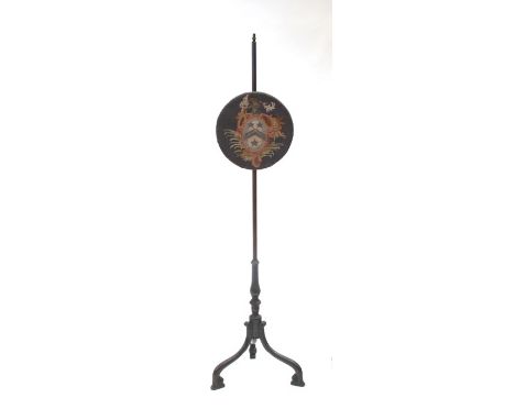 A 19th century rosewood pole screen with circular needlework panel, on a tripod base.