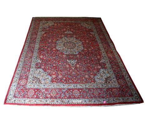 A Persian Mashad hand knotted woollen carpet with central floral medallion within foliate borders, 400 by 290cms (157.5 by 11